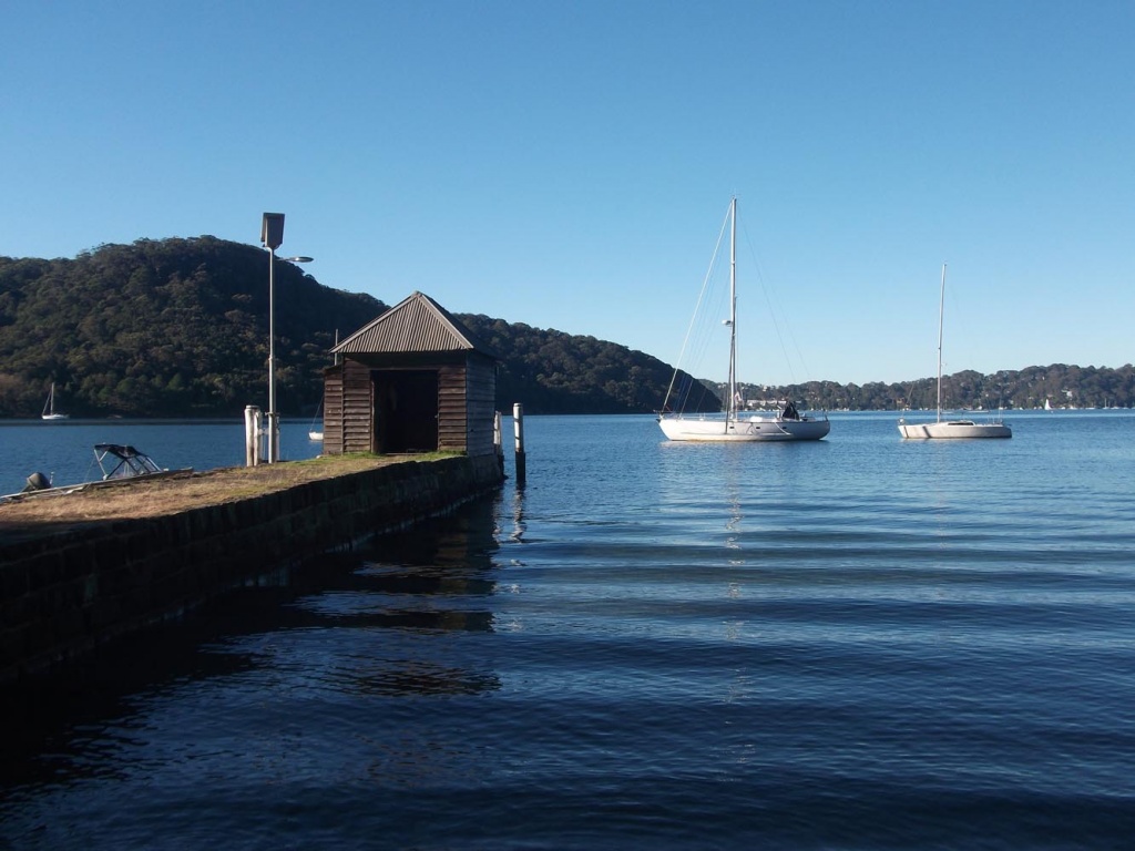 The old boatshed and moored yachts in Morning Bay