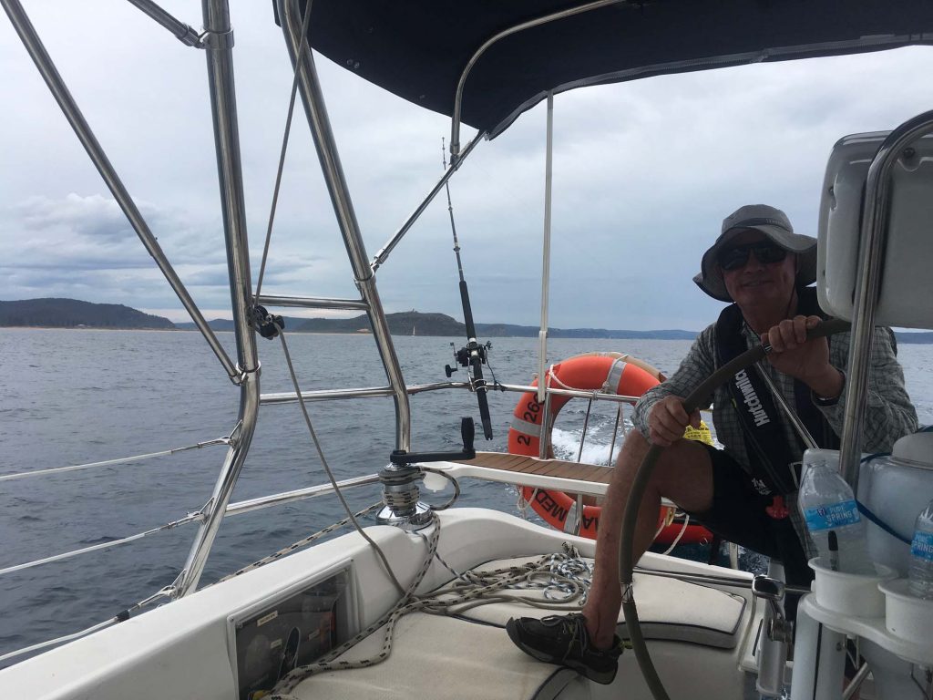 Guest relaxing in the cockpit while sailing Pittwater