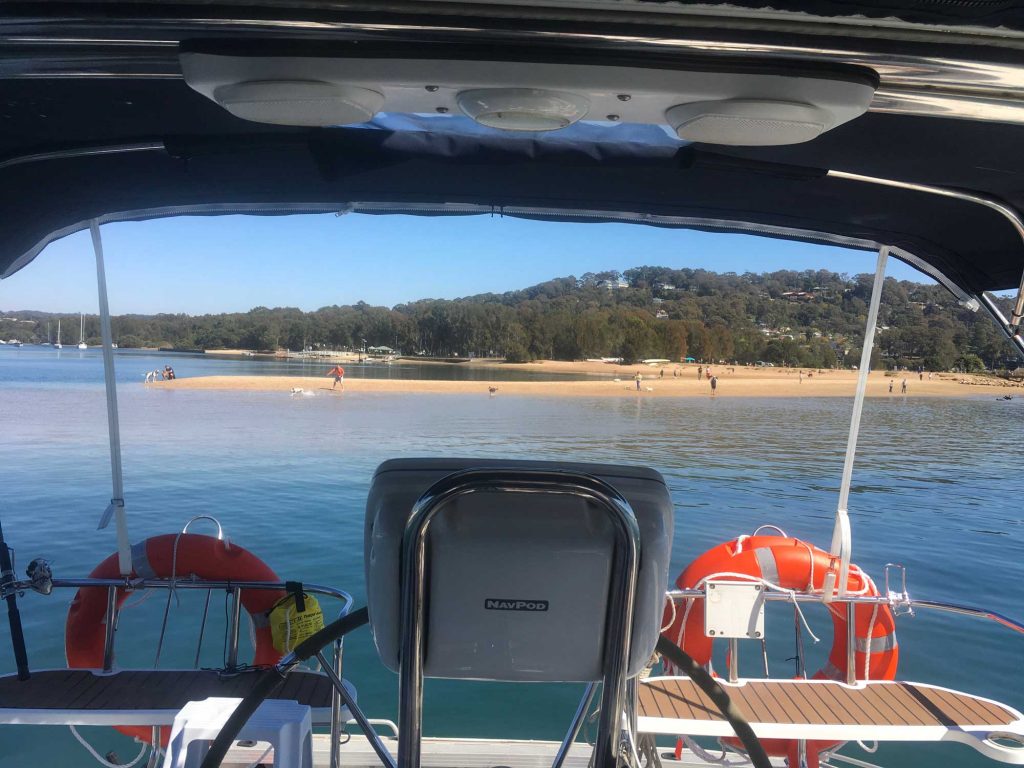 Looking out to a Pittwater beach from the shade of the cockpit