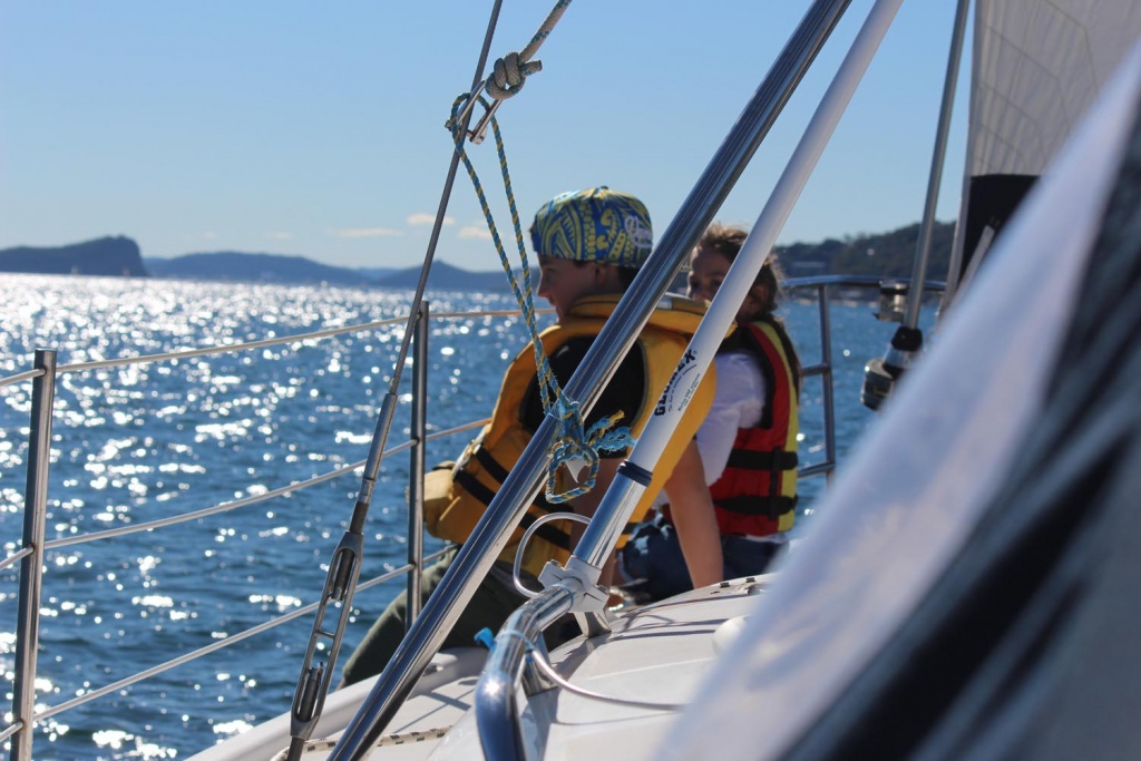 Young crew member at the rail while sailing